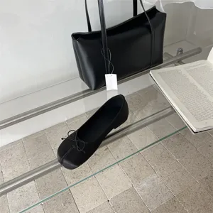 Black split-toe flat shoes for women with elegant bow detail and modern minimalist style.