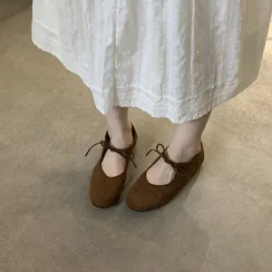 Brown lace-up bow Mary Jane flat shoes detailed shot, soft sole minimalist casual footwear.