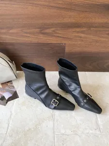 Detailansicht eleganter schwarzer Damen Stiefeletten mit spitzer Kappe und Metall Schnalle.