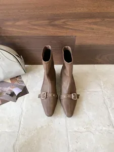 Detailansicht stilvoller brauner Stiefeletten mit spitzer Kappe, Blockabsatz und Schnallen.