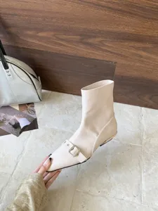 Detailansicht eleganter beiger Stiefeletten mit spitzer Kappe und flachem Blockabsatz.