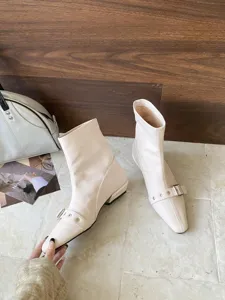 Detailansicht trendy spitzer Zeh niedriger Blockabsatz Stiefeletten mit Metall Schnalle.