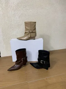 Nahaufnahme von spitzen Keilabsatz Stiefeletten mit stilvollen seitlichen Metall Schnallen.