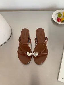 Vue détaillée de sandales à talons marron ornées de strass en forme de cœur et lanières.