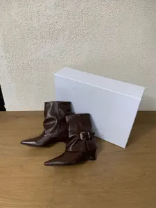 Braune spitze Keilabsatz Western Kurzstiefel Detail mit Schnalle und Knautschschaft.