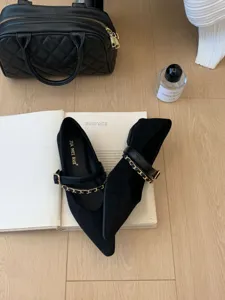 Nahaufnahme stilvoller schwarzer spitzer Mary Jane Flache Schuhe mit Kettendetail.