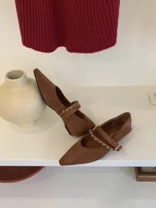 Detailansicht brauner Wildleder-Spitzen-Mary-Janes mit elegantem goldenen Kettenriemen.