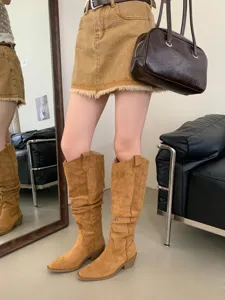 Vue détaillée de bottes western slouchy en suédine marron à talons épais et bout pointu.