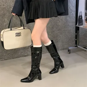 Botas altas de charol negro con tacón ancho y correas con hebilla para la moda femenina.