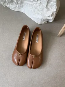 Close-up detail of stylish brown split-toe flats featuring soft leather and unique design.