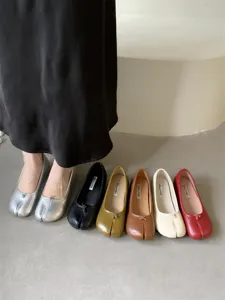 Detail shot of soft leather split toe flat shoes featuring front knot and multi color display.