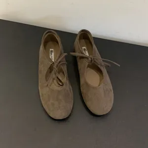 Brown suede lace-up ballet flats detail view, soft flat sole women shoes display.