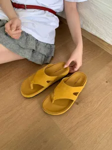 Detail view of stylish yellow suede-like thong sandals with thick sole for women beach wear