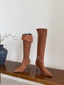 Bruine suède hoge hakken laarzen detail met puntige neus en een elegante slanke hak.