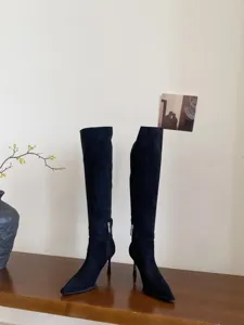 Detailopname van zwarte puntige stiletto hoge hak laarzen, elegante suède schoenen online.