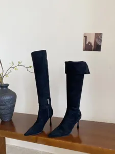 Gedetailleerd overzicht van zwarte spitse stiletto hoge laarzen, chique en elegante dames schoenen.