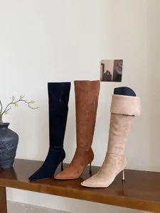 Gedetailleerd weergave van suède lange laarzen met hoge hak en puntige neus in diverse kleuren.