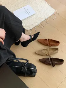 Detailaufnahme von spitz zulaufenden Mary-Jane-Keilabsatzschuhen mit Kettendetail.