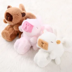 Vista dettagliata di simpatici bracciali a scatto angelo capibara in peluche marrone, rosa.