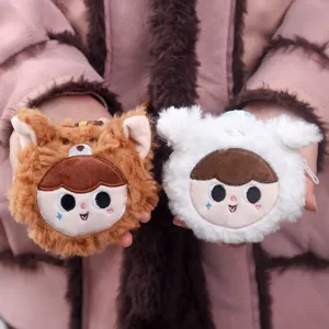 Primo piano di simpatici portamonete in peluche con ricamo del viso e materiale morbido.