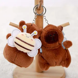 Primo piano dettagliato del portachiavi peluche capibara con zainetto ape dolce.