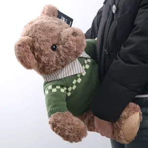 Brown teddy bear plush toy wearing a green knitted sweater with striped collar, cute companion.