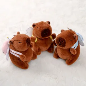 Vista dettagliata di simpatici ciondoli in peluche capibara con ali, morbidi giocattoli.