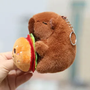 Cute capybara plush keychain detail close up showing soft brown fur and burger toy charm.
