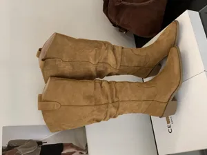 Détail bottes slouch daim marron, bottes western pointues talon bloc style vintage élégant.