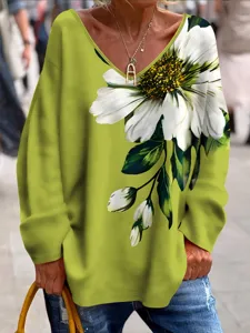 Gros plan sur le t-shirt vert olive à manches longues et col V avec un grand imprimé marguerite.