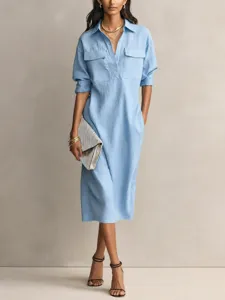 Light blue midi shirt dress detail showing chest pockets, collar and button closure.