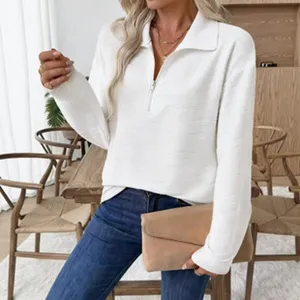 Nahaufnahmedetail eines stylischen weissen Langarm-Zip-Poloshirts, drinnen an Modell.