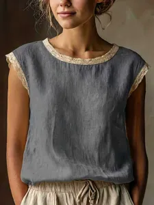Closeup view of vintage loose sleeveless linen shirt with delicate beige lace trim and crew neck.