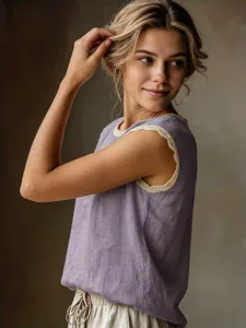 Detail shot of a vintage sleeveless linen blouse with delicate lace trim on the round neck.