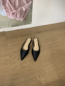 Vue détaillée de chaussures plates pointues tissées noires au style et texture élégants.
