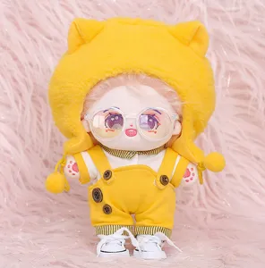 Graziosa bambola di peluche di cotone con cappello da gatto giallo, salopette e accessori.