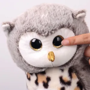 Close-up shot of the cute owl plush toy showing soft grey fur and big sparkly eyes.
