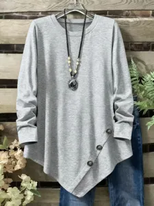 Grey asymmetric button hem long sleeve top detail view, casual round neck tunic garment.