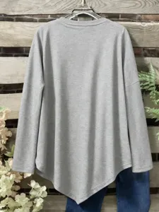 Detail view of the solid grey long sleeve top showcasing its unique irregular hemline texture.