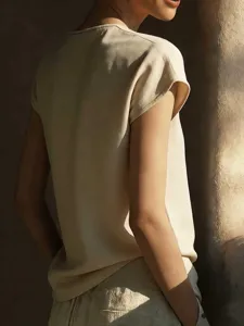 Detailed shot of elegant beige short sleeve women blouse, soft fabric texture view.