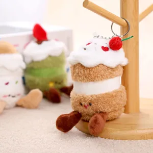 Detailaufnahme des süßen Kuchen Plüschtier Schlüsselanhängers mit Kirsch-Anhänger auf Holzständer.