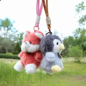 Dettaglio del ciondolo in peluche con design animale carino, cordino e gancio in metallo.
