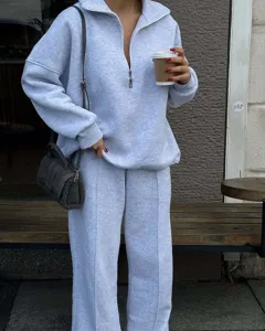 Outdoor street detail view of casual grey half-zip sweatshirt and matching trousers lounge set.