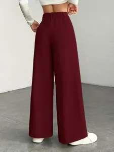 Detailed view of women high waisted knit wide leg pants in burgundy showing fit from back.