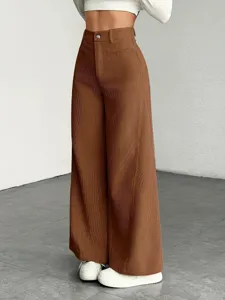 Detailed shot of brown high-waist pleated wide leg pants featuring comfortable tailored fit.
