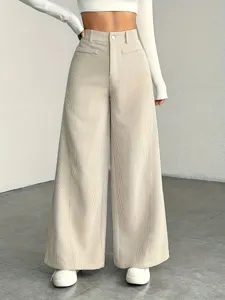 Close-up detail of high-waist beige corduroy wide-leg trousers, soft textured fabric.