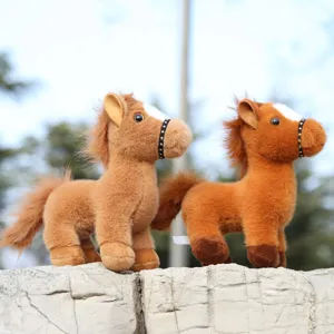 Detail shot of cute brown plush horse toys standing outdoors on stone ledge, soft toy.
