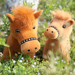 Detailed view of cute realistic plush horse toy outdoors in grass, soft stuffed animal toy.