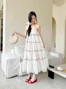Elegant summer spaghetti strap white dress paired with red wedge high heels for women.