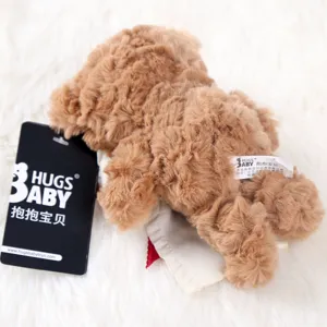 Detailed view of brown plush teddy bear pendant with brand tag and wash label, soft texture.